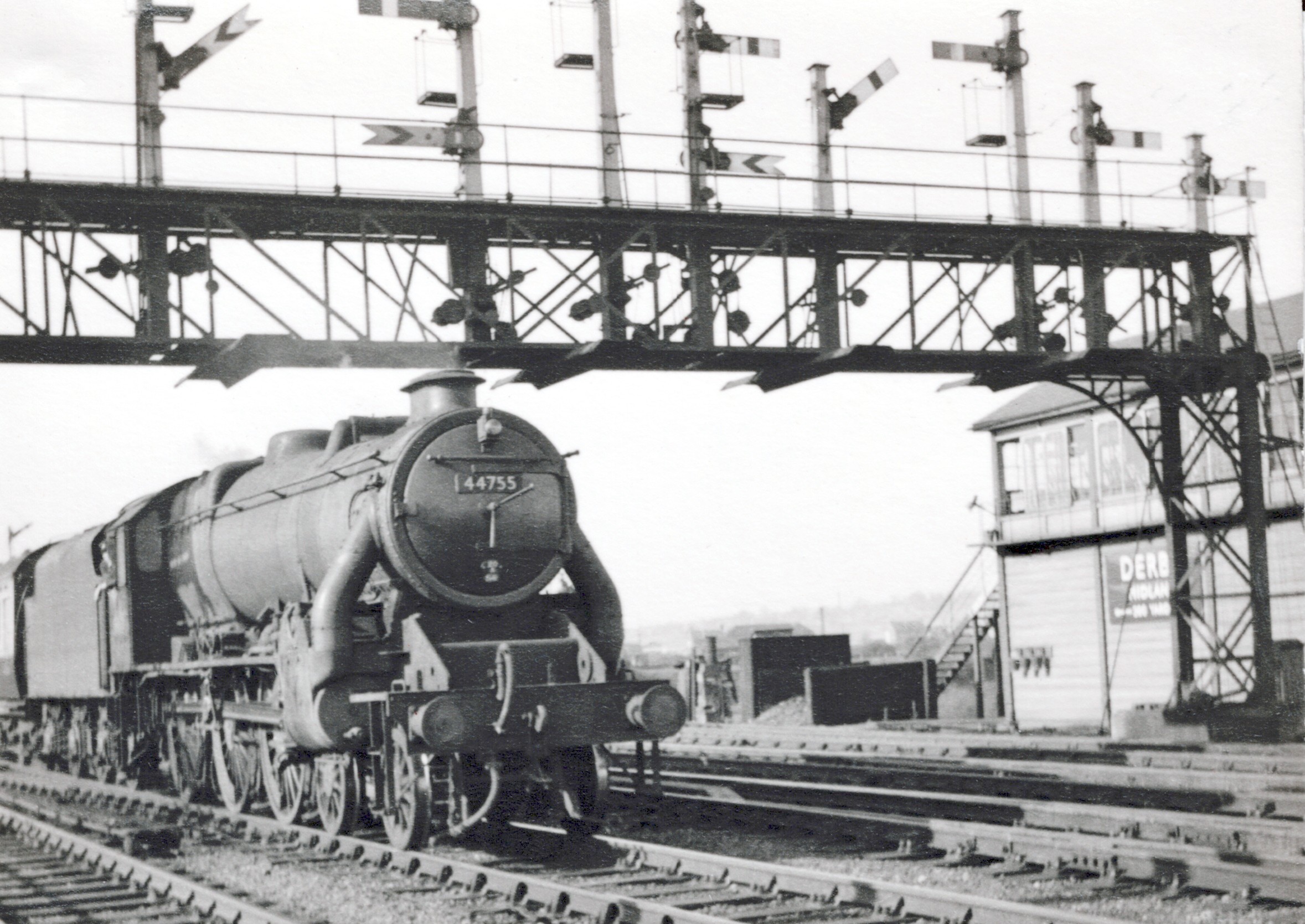 A photograph looking northmeat across four lines of railway shwoing No.44755 entering Derby from the north with Derby Junction Signal Box in the background.